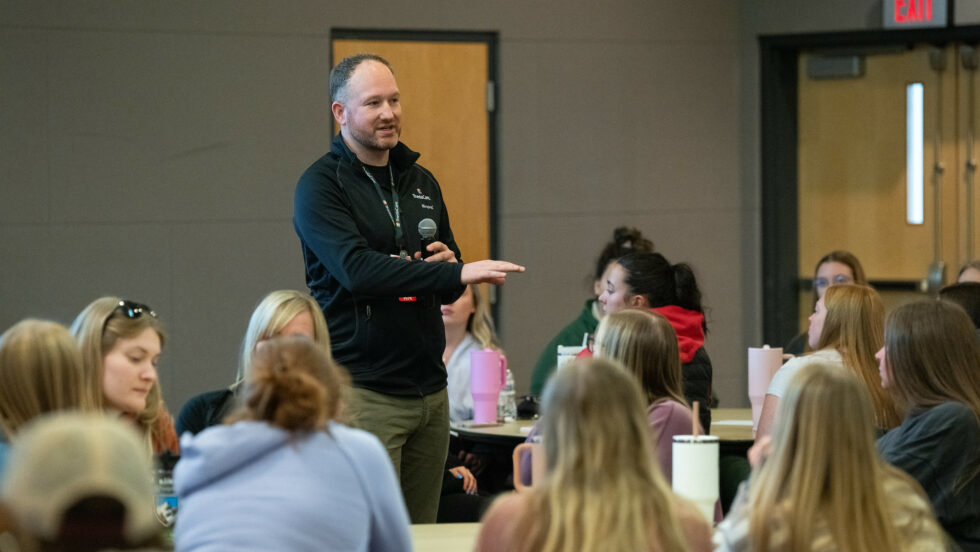 Photo of Jamin Homan, director of patient safety for ThedaCare, addressing a large group of student nurses at the University of Wisconsin–Oshkosh.