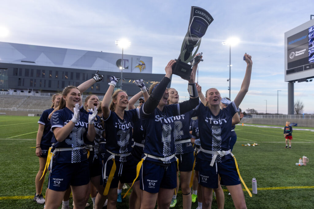 Photo of Quarterback Allison Letcher hoisting the championship trophy following the Blue Devils' victory in the Midwest College Women’s Flag Football League Championship at the Minnesota Vikings' TCO Performance Center April 26.