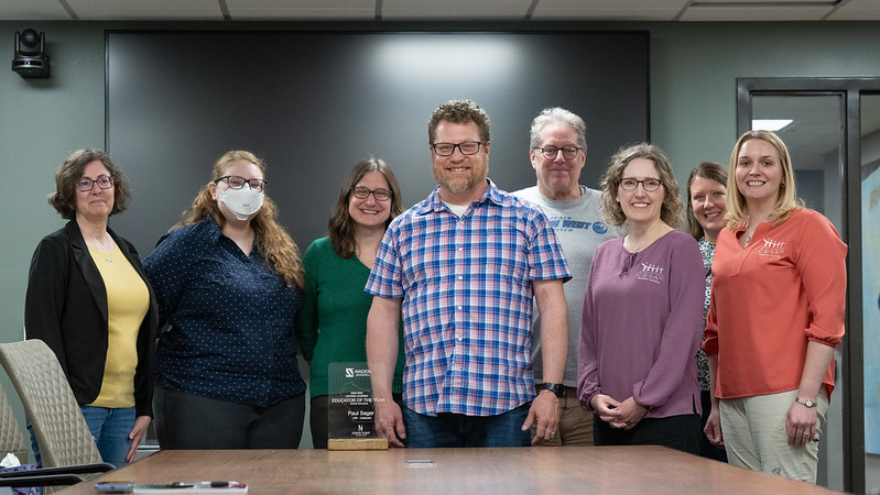 Photo of UWO lecturer Paul Sager of Appleton, center, who gathers with co-workers and a representative of CESA 10 and was recently was honored with an award naming him Higher Education Distance Educator of the Year.