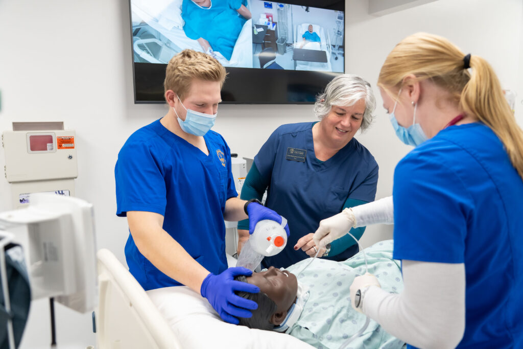 Photo of UW-Eau Claire nursing students working with Kristen Abbot-Anderson in the SIMS lab.