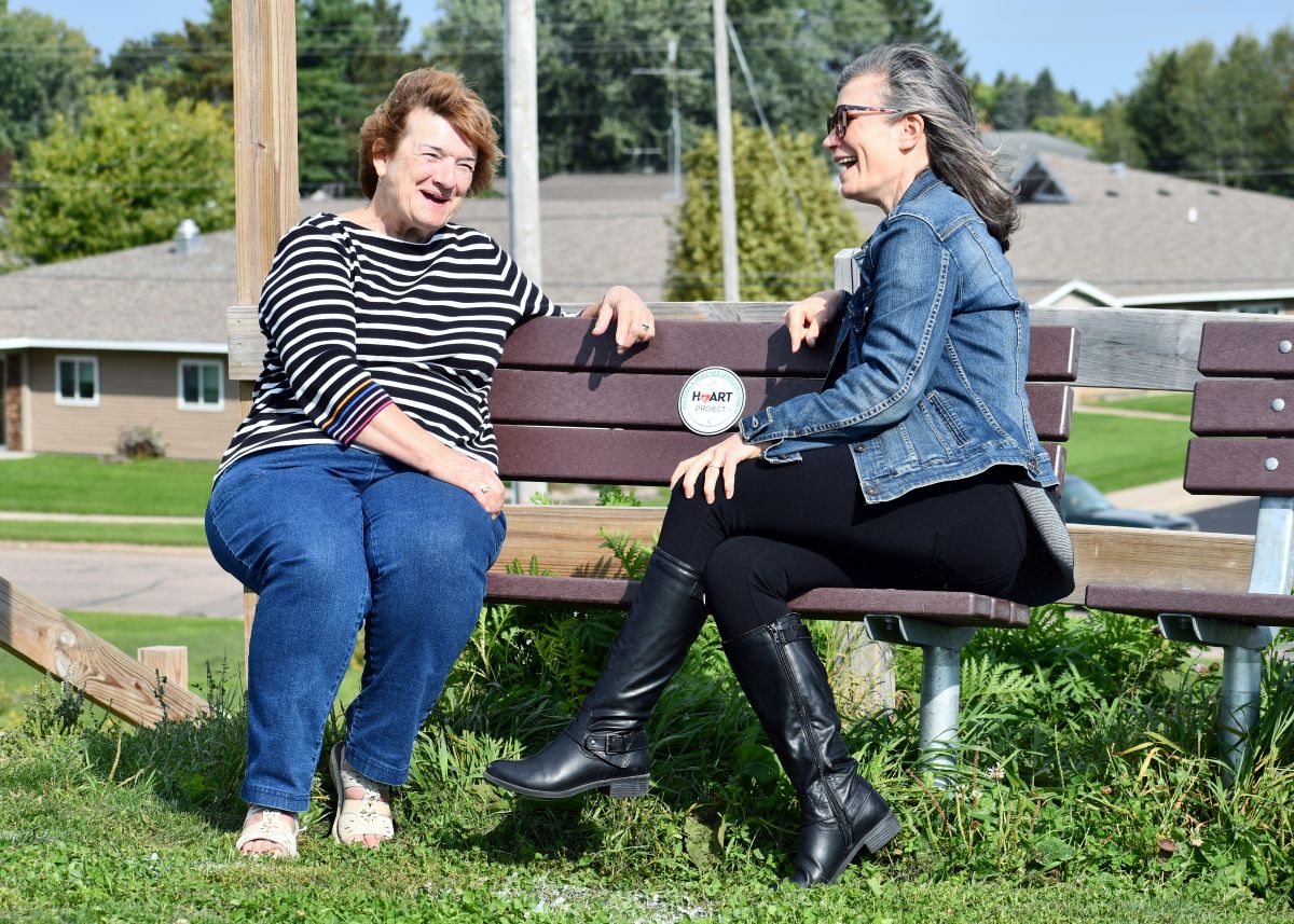 Photo: Members of the Langlade County Healthy Aging in Rural Towns (HeART) coalition sit at one of the many HeART benches strategically placed around pedestrian areas to provide places to rest. (Photo by Heidi E. Johnson)
