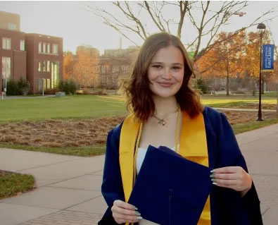 Photo: This fall, Lewis has been completing her full-time teaching practicum, commuting to her placement from her family home in Savage, Minnesota. She made a weekend trip to campus recently for cap and gown photos with friends.